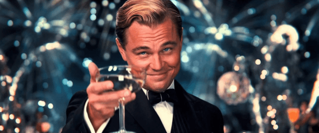 Actor Leonardo DiCaprio holding champagne glass in a cheers motion.