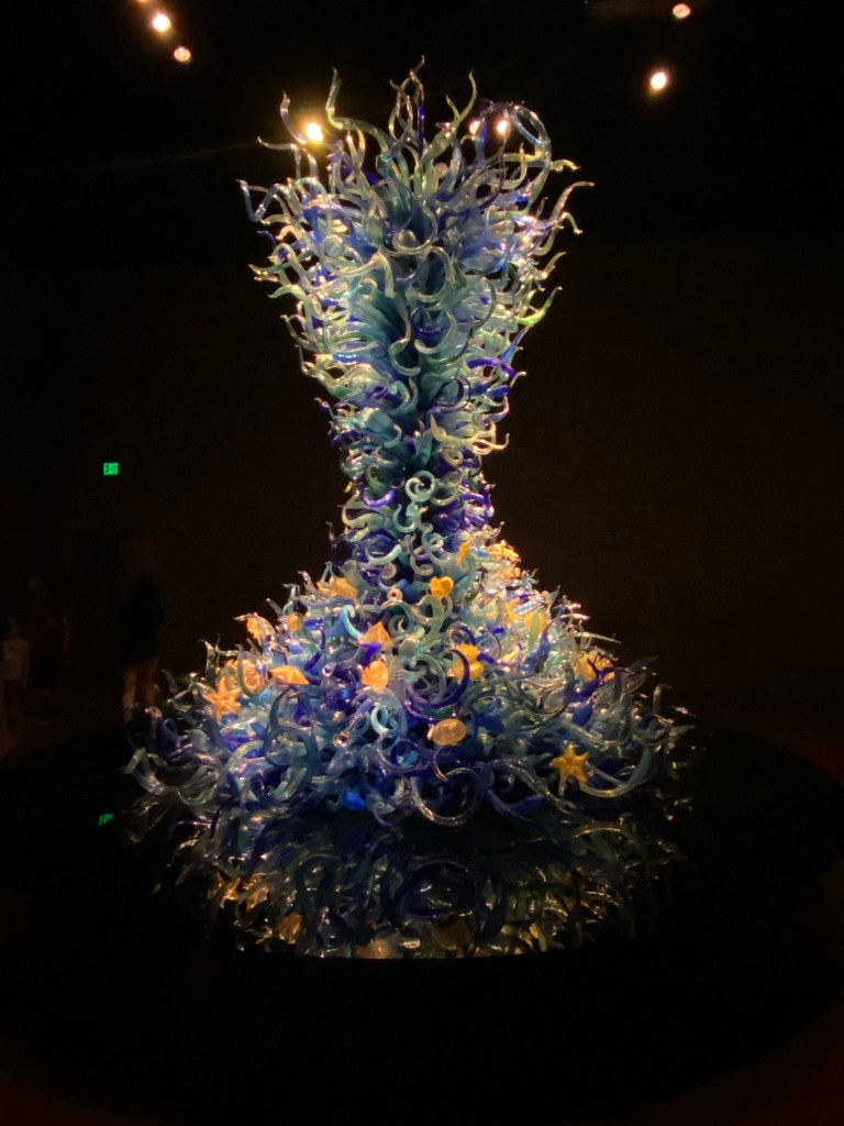 Tall structure of glass swirls in the shape of a vase.