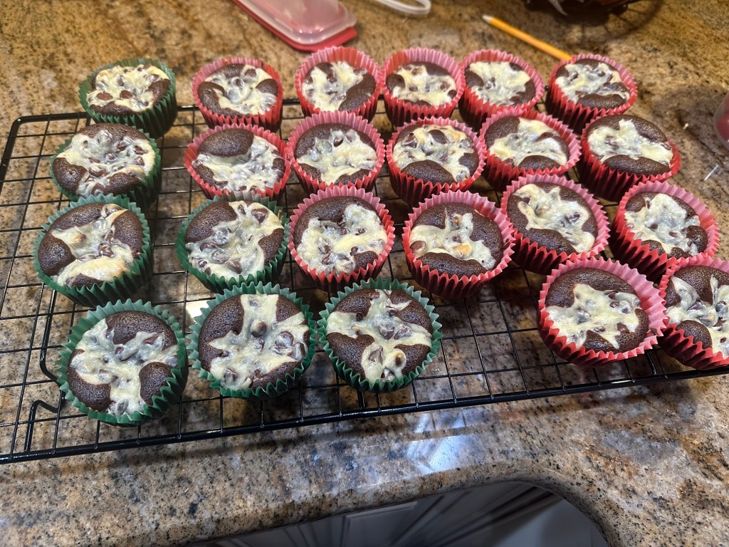 Chocolate cupcakes sitting on top of a drying rack.