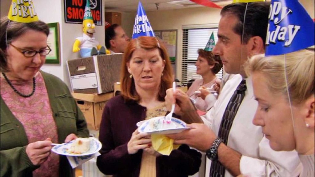 From the show, The Office, where Phyllis, Meredith, Michael, and Angela, are standing in a half circle, eating their slice of cake in silence.